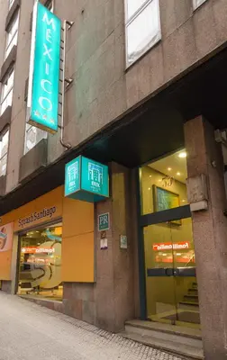 a store with signs on the side of a building at México PR in Santiago de Compostela