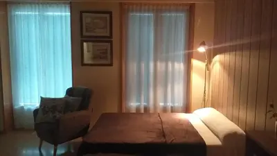 a bedroom with a bed and a chair and window at Loft Plaza Mayor in Ourense