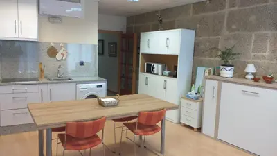 a kitchen with a wooden table and orange chairs at Loft Plaza Mayor in Ourense
