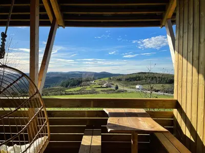 a porch with a bench and a view of the mountains at Olladas de Barbeitos in Fonsagrada