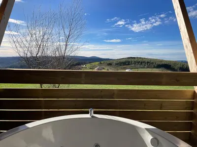 a bath tub sitting next to a wooden fence at Olladas de Barbeitos in Fonsagrada