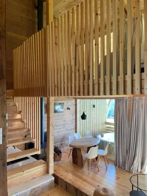 a wooden house with a staircase and a table and chairs at Olladas de Barbeitos in Fonsagrada
