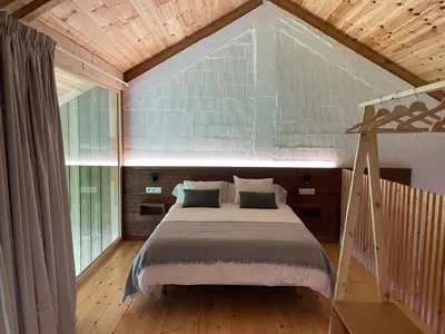 a bedroom with a bed and a large window at Olladas de Barbeitos in Fonsagrada