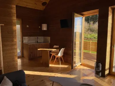a living room with a table and a kitchen at Olladas de Barbeitos in Fonsagrada