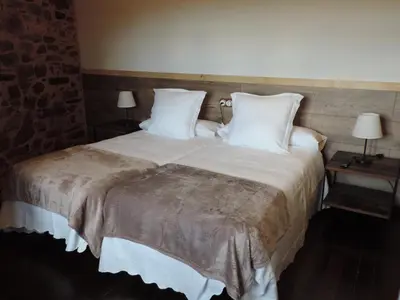 a bedroom with a large bed with white sheets and pillows at El Rincón Maragato in Castrillo De Los Polvazares