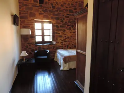 a hotel room with a bed and a window at El Rincón Maragato in Castrillo De Los Polvazares