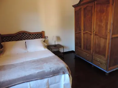 a bedroom with a large bed and a wooden cabinet at El Rincón Maragato in Castrillo De Los Polvazares