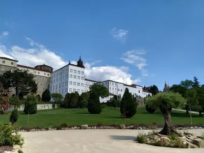 a building with a tree in the middle of a park at San Francisco Hotel Monumento in Santiago de Compostela