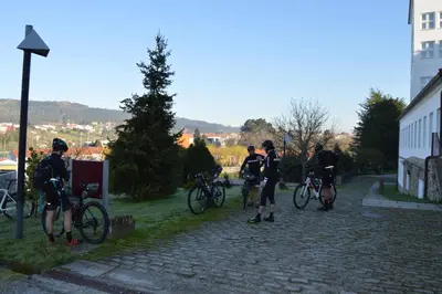 a group of people standing with bikes on a street at San Francisco Hotel Monumento in Santiago de Compostela