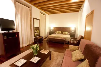 a large living room with a bed and a couch at San Francisco Hotel Monumento in Santiago de Compostela