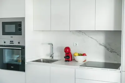 a white kitchen with a sink and a microwave at Morar Ourense in Ourense