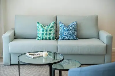a living room with a couch with pillows and a table at Morar Ourense in Ourense