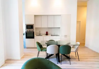 a dining room with a glass table and green chairs at Morar Ourense in Ourense