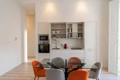a dining room with a glass table and orange chairs at Morar Ourense in Ourense
