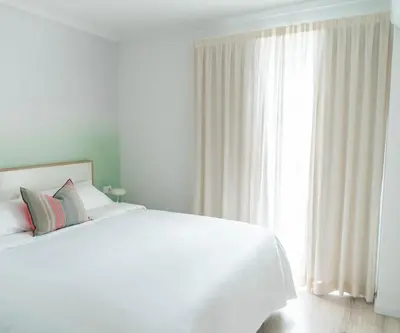 a white bedroom with a bed and a large window at Morar Ourense in Ourense