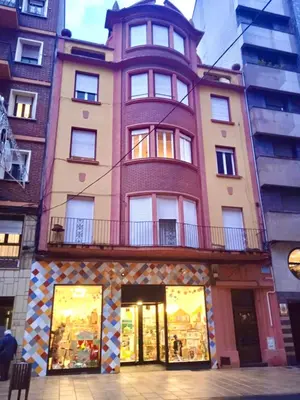 a tall building with a balcony on top of it at Antolín Yellow Door in Ponferrada