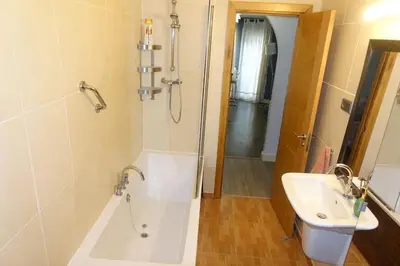 a bathroom with a shower and a tub and a sink at Antolín Yellow Door in Ponferrada