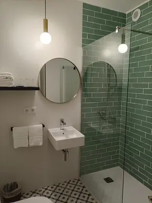 a bathroom with a sink and a mirror and a shower at Hostal Quiper in Quiroga
