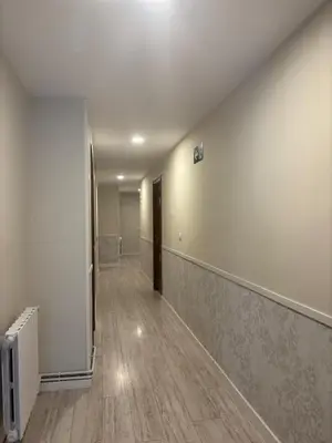 an empty room with a hallway with a door and wood floors at Hostal Quiper in Quiroga