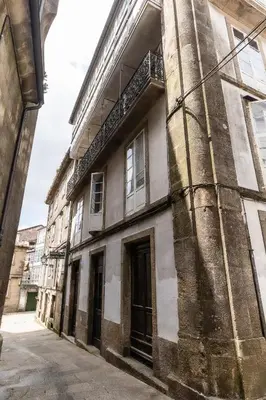 a building with a black door with a sign on it at Hostal San Pelayo in Santiago de Compostela