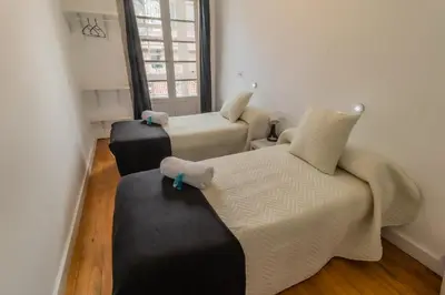 a room with two beds and a couch and a window at Hostal San Pelayo in Santiago de Compostela