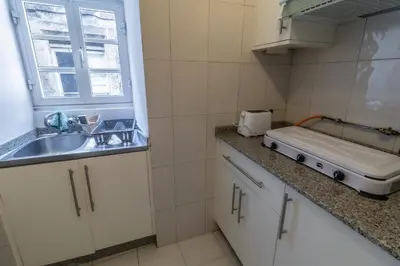 a small kitchen with a sink and a window at Hostal San Pelayo in Santiago de Compostela