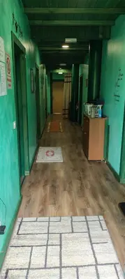 an empty hallway of a building with green walls and wooden floors at ALBERGUE peregrinos CASAFLOR in Murias de Rechivaldo