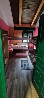 a room with two bunk beds and a green door at ALBERGUE peregrinos CASAFLOR in Murias de Rechivaldo