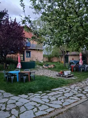 a group of tables and chairs in a yard at ALBERGUE peregrinos CASAFLOR in Murias de Rechivaldo