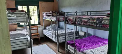 a room with three bunk beds and a window at ALBERGUE peregrinos CASAFLOR in Murias de Rechivaldo