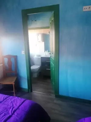 a bedroom with a bed and a bathroom with a sink at ALBERGUE peregrinos CASAFLOR in Murias de Rechivaldo