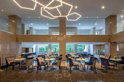 a restaurant with tables and chairs and a chandelier at Eurostars Gran Hotel Lugo in Lugo
