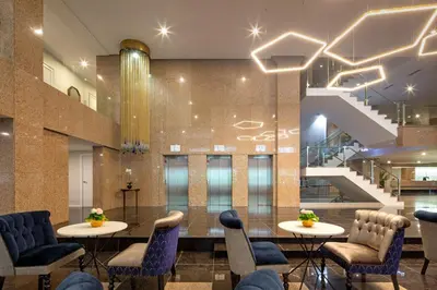 a lobby with two tables and chairs and stairs at Eurostars Gran Hotel Lugo in Lugo