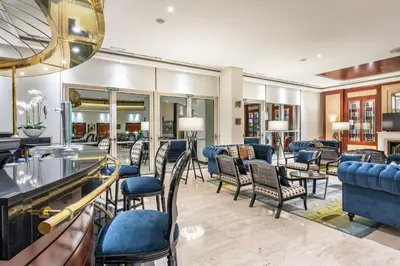 a hotel lobby with chairs and a bar at Eurostars Gran Hotel Santiago in Santiago de Compostela