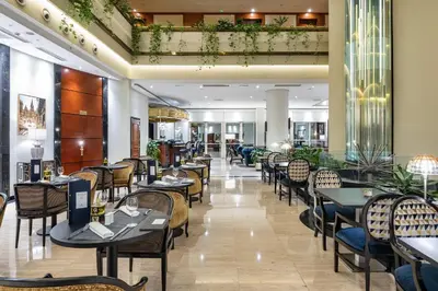 a restaurant with tables and chairs in a room at Eurostars Gran Hotel Santiago in Santiago de Compostela