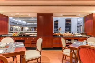 a restaurant with wooden tables and chairs and a buffet at Eurostars Gran Hotel Santiago in Santiago de Compostela