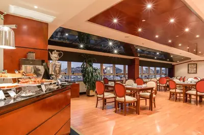 a restaurant with tables and chairs and a buffet at Eurostars Gran Hotel Santiago in Santiago de Compostela