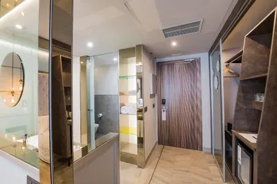 a hallway with a glass door and a bathroom at Barceló Ourense in Ourense
