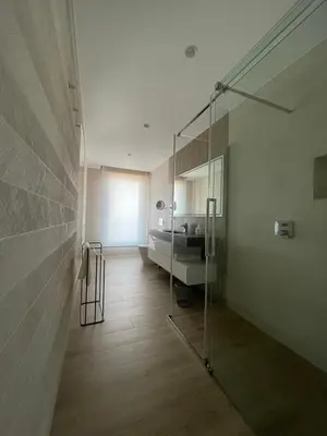a bathroom with a glass shower and a sink at El Roble 9 in Astorga