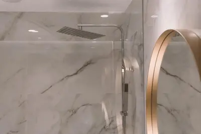 a shower with a glass door and a mirror at HOTEL CANDOR in A Lama