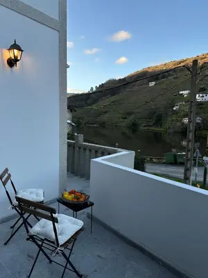 a balcony with a chair and a bowl of fruit on a table at Casa Amodiño in Belesar