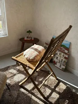 a wooden chair sitting on a rug with a table at Casa Amodiño in Belesar