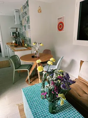 a living room with a table with a vase of flowers at Amodiño do Camiño in Belesar