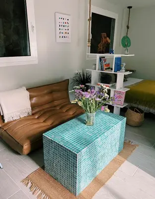 a living room with a couch and a table with flowers at Amodiño do Camiño in Belesar