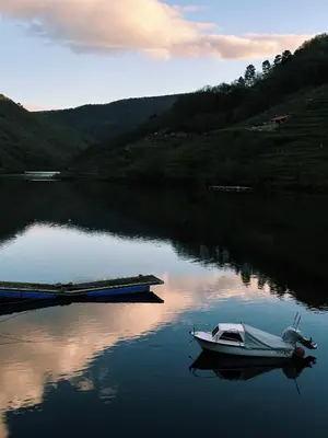 a boat is docked on a lake at Amodiño do Camiño in Belesar
