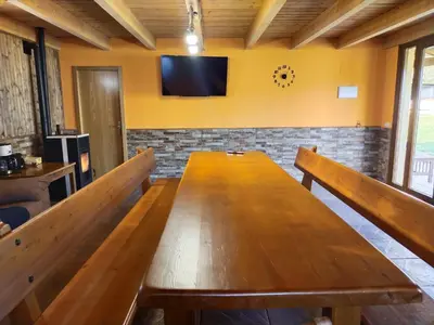 a large wooden table in a room with a tv on the wall at Casa Antonio in Susañe del Sil