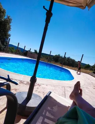 a person laying in a chair next to a swimming pool at Casa Antonio in Susañe del Sil