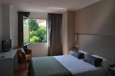 a hotel room with a bed and a window at Duerming Villa De Sarria Hotel in Sarria