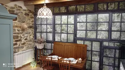 a dining room with a table and some windows at Casa el rey 12 - Apartamentos Buenos Aires y Figueras AR-1419-AS in Valbona