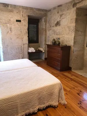 a bedroom with a white bed and a dresser at Casa Lisboana in Pontevedra
